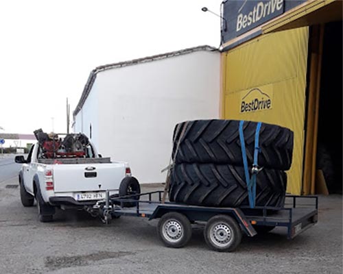 Servicio de Asistencia BestDrive Azuaga Vehículo de servicio de asistencia saliendo del taller con ruedas de tractor.